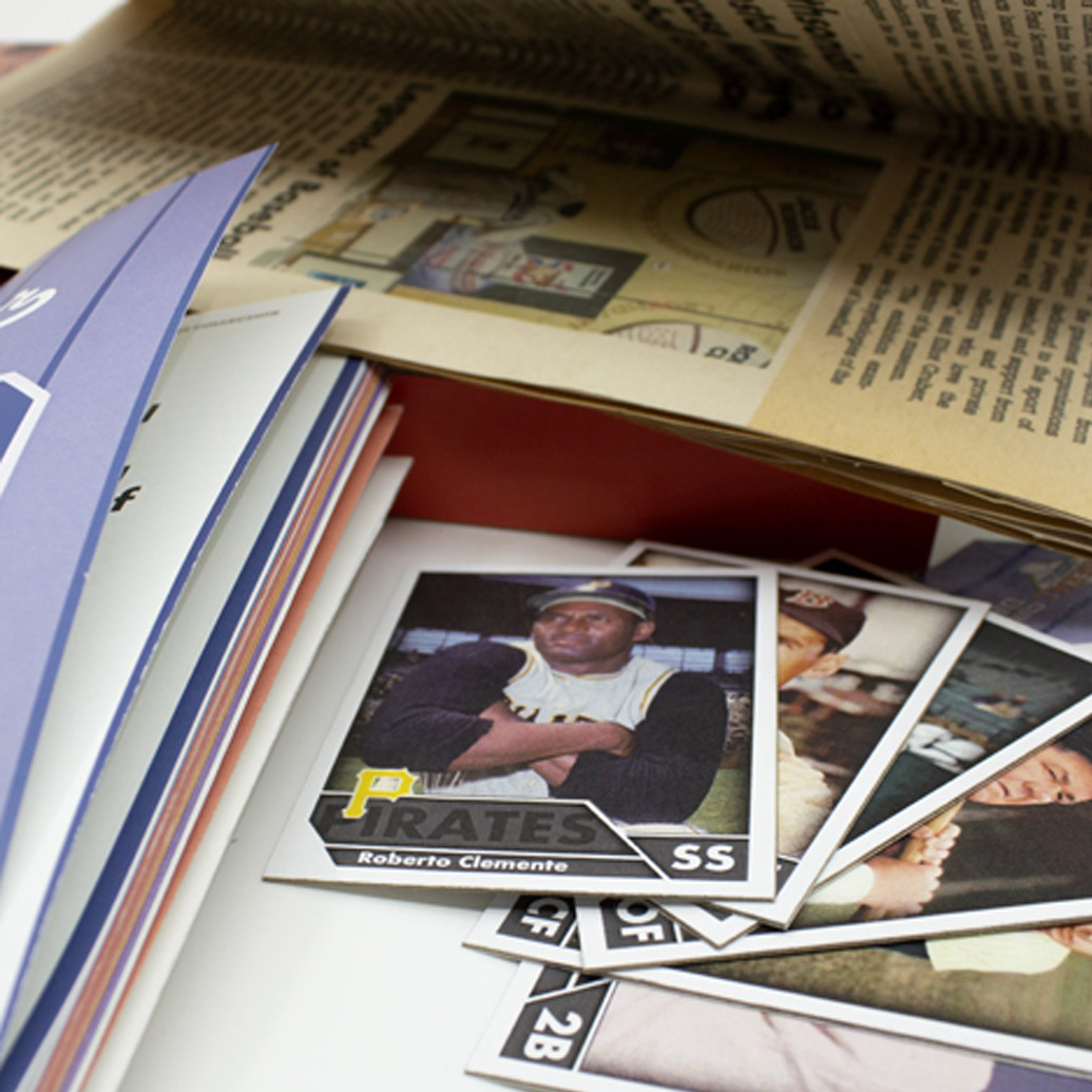 A square with baseball player cards and a folded newspaper in the backbground