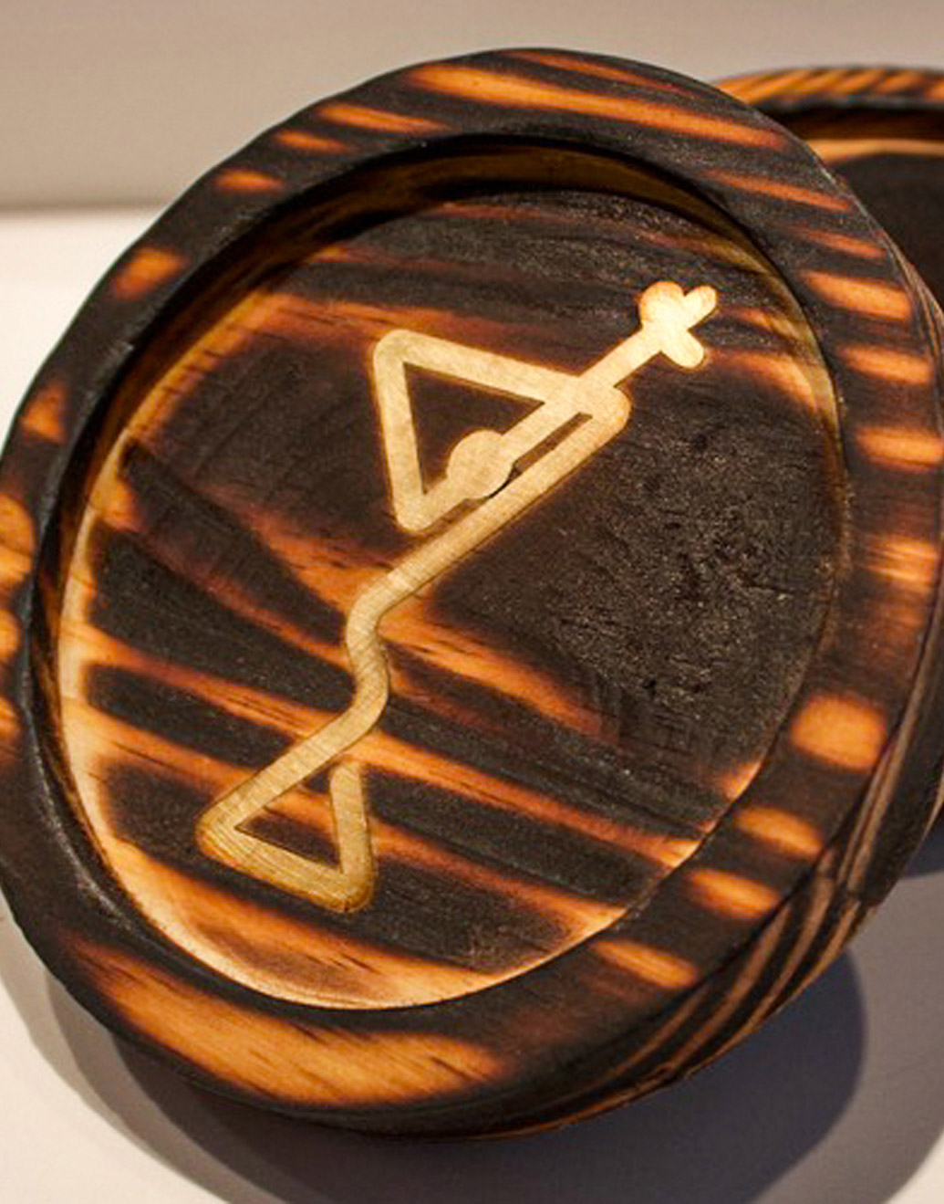 Cropped image of wooden coaster with gold inlay of a martini glass